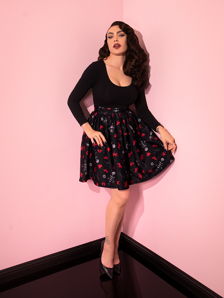 Full length shot of Micheline Pitt wearing the EDWARD SCISSORHANDS Skater Skirt in “I am not complete” Novelty Print and black low-cute retro style top from Vixen Clothing.