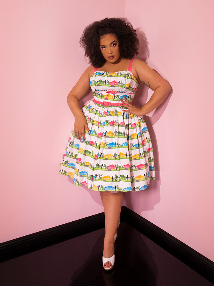 Full length shot of Ashleeta posing with one hand on her hip and the other resting on the skirt section of the EDWARD SCISSORHANDS Vintage Sundress in Suburban Topiary Novelty Print.
