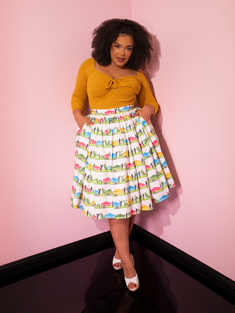 Model tucking her hands into the pockets of the EDWARD SCISSORHANDS Swing Skirt in Suburban Topiary Novelty Print.