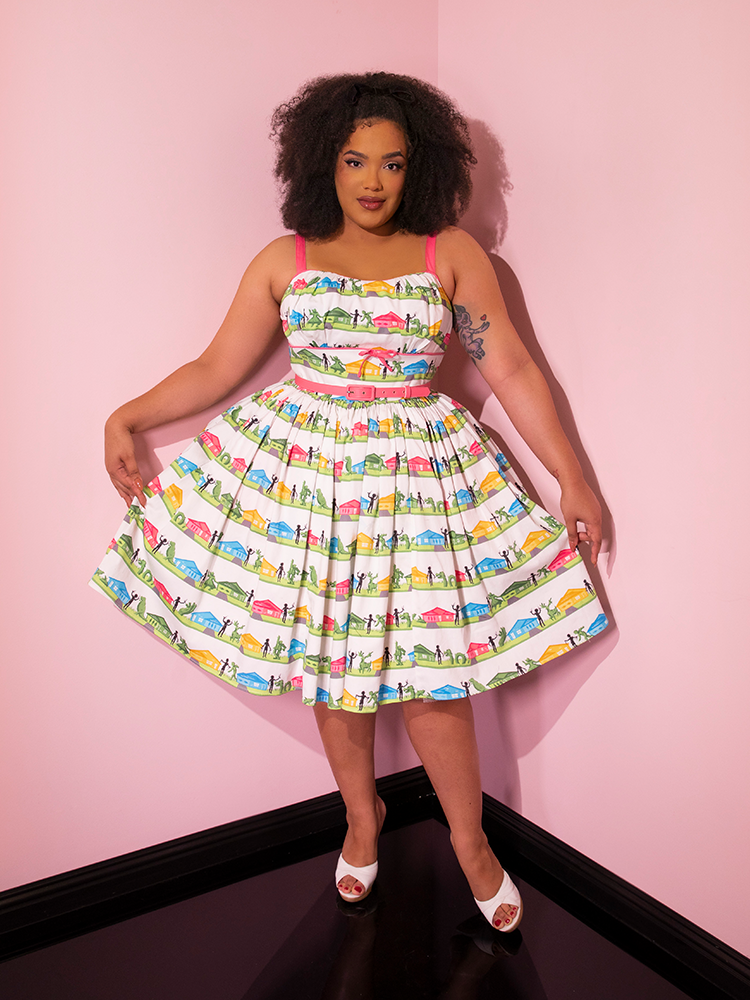 Ashleeta pulls out the sides of the skirt section on the EDWARD SCISSORHANDS Vintage Sundress in Suburban Topiary Novelty Print to show off the intricate and cute print.