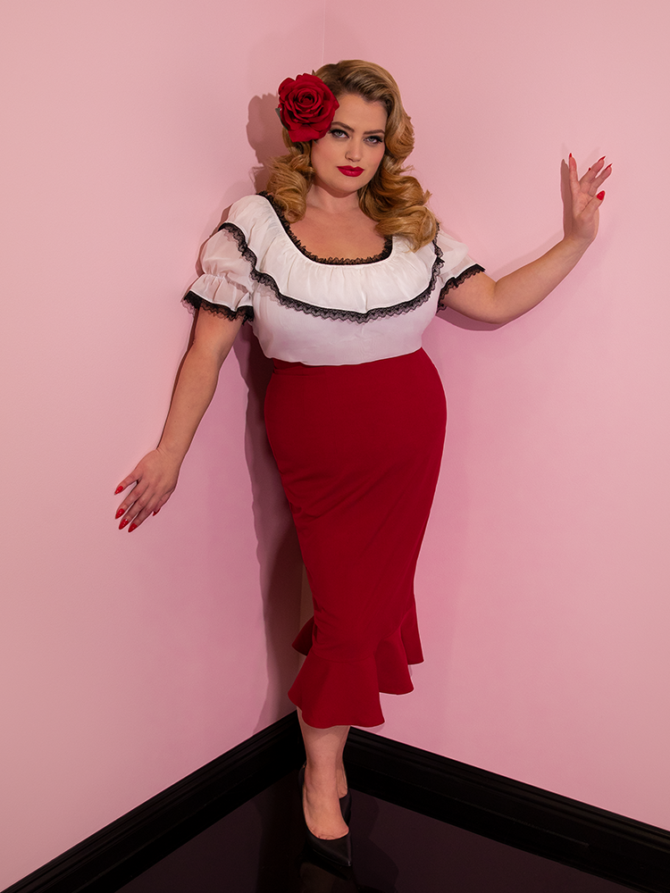 Blondie with a red rose in her hair modeling the Vixen flutter skirt in red paired with a white peasant top.