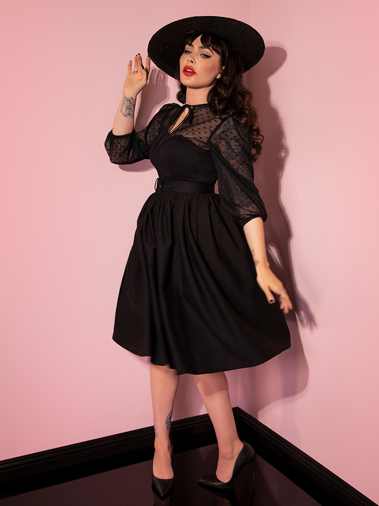 Micheline Pitt twirls around in the Frenchie Swing Dress in Black from retro clothing brand Vixen Clothing.