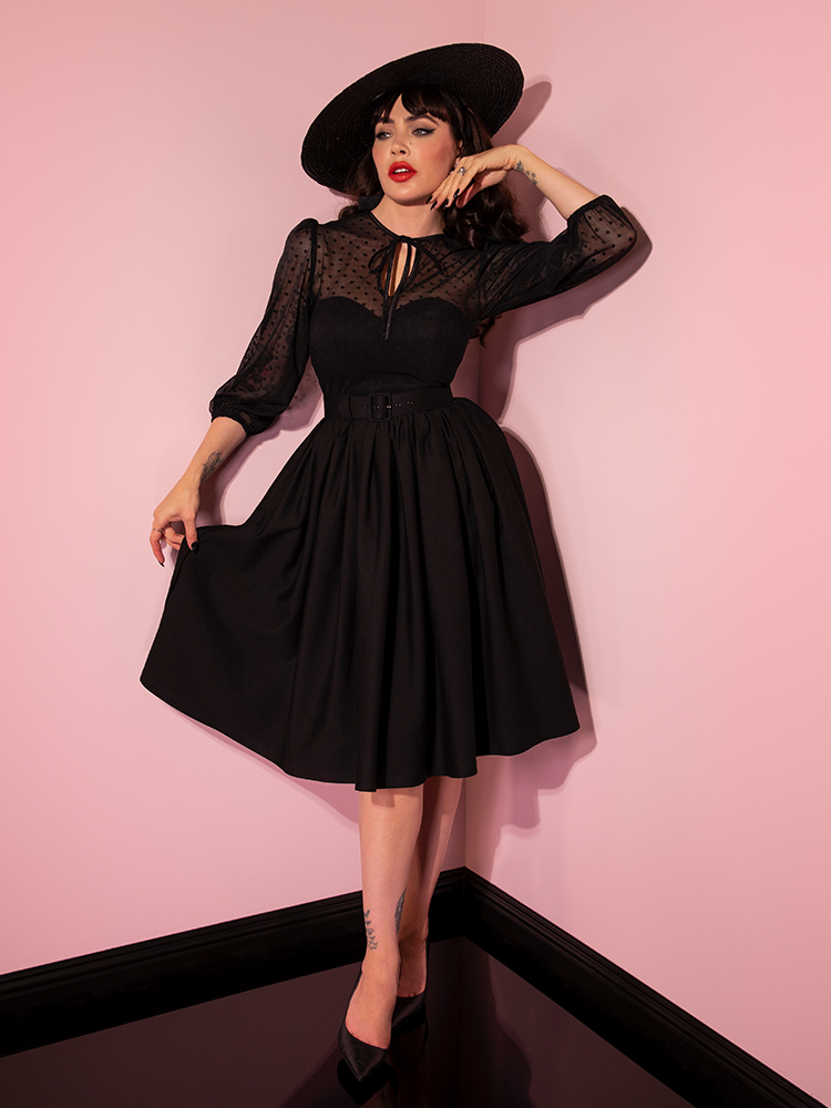 Full length shot of Micheline Pitt in the Frenchie Swing Dress in Black from retro dress company Vixen Clothing.