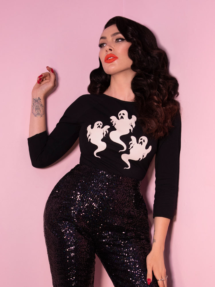 Raven haired model and owner Micheline Pitt showing off the latest sexy and spooky outfit from Vixen Clothing- a black long-sleeve ghost top with black sequin pants.