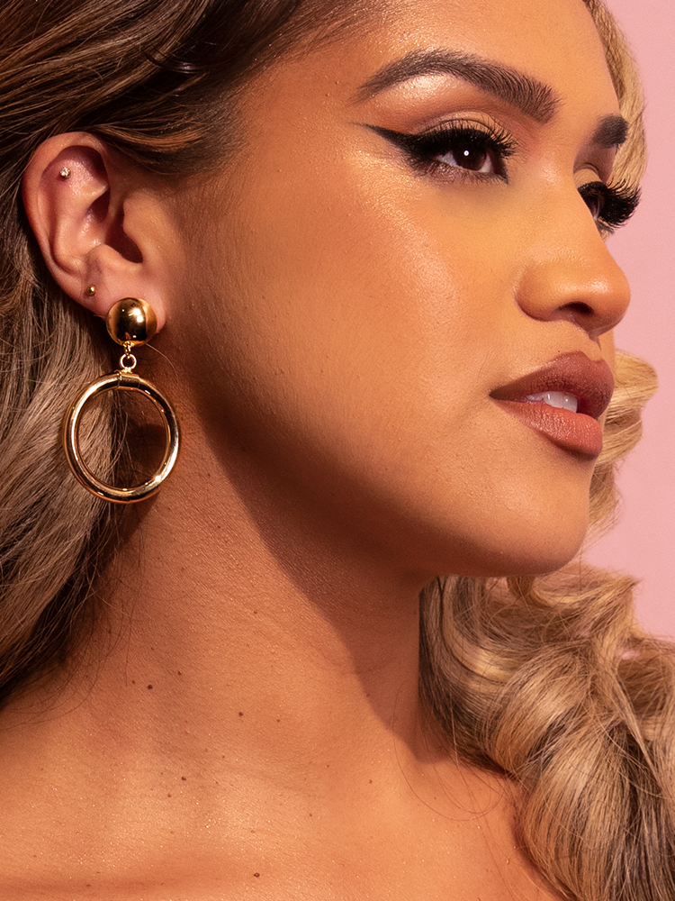 Gabby wearing the Bad Girl Hoop Earrings in Gold from retro dress and clothing brand, Vixen Clothing.