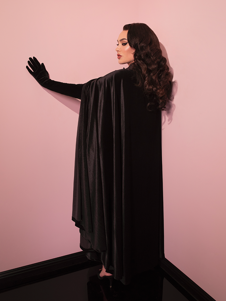 Micheline Pitt turned away from the camera to show off the back of the Golden Era Cape in Black Velvet.