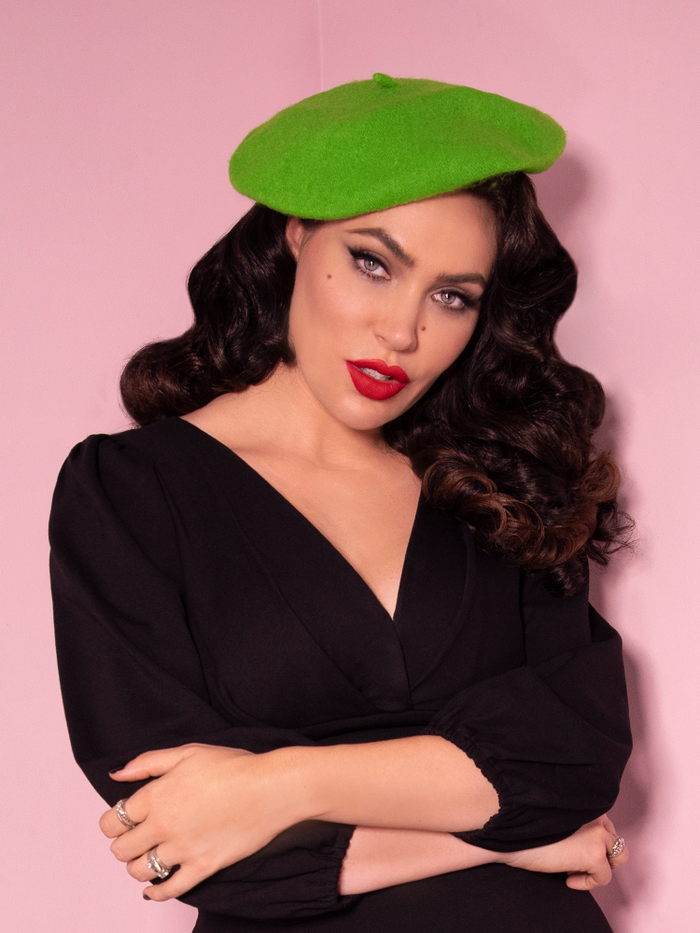 Micheline Pitt shot from the waist up wearing a green beret with a long sleeve top.
