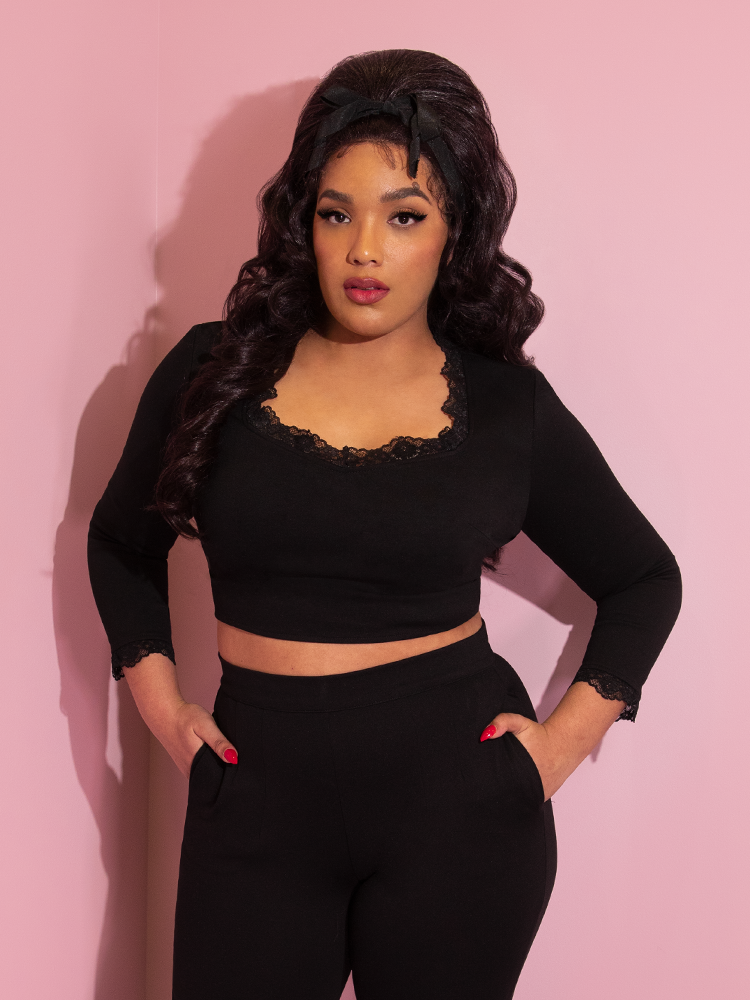 A closeup of Ashleeta with her hands in her pockets modeling the Vixen Clothing Hollywood crop top paired with matching black pants.