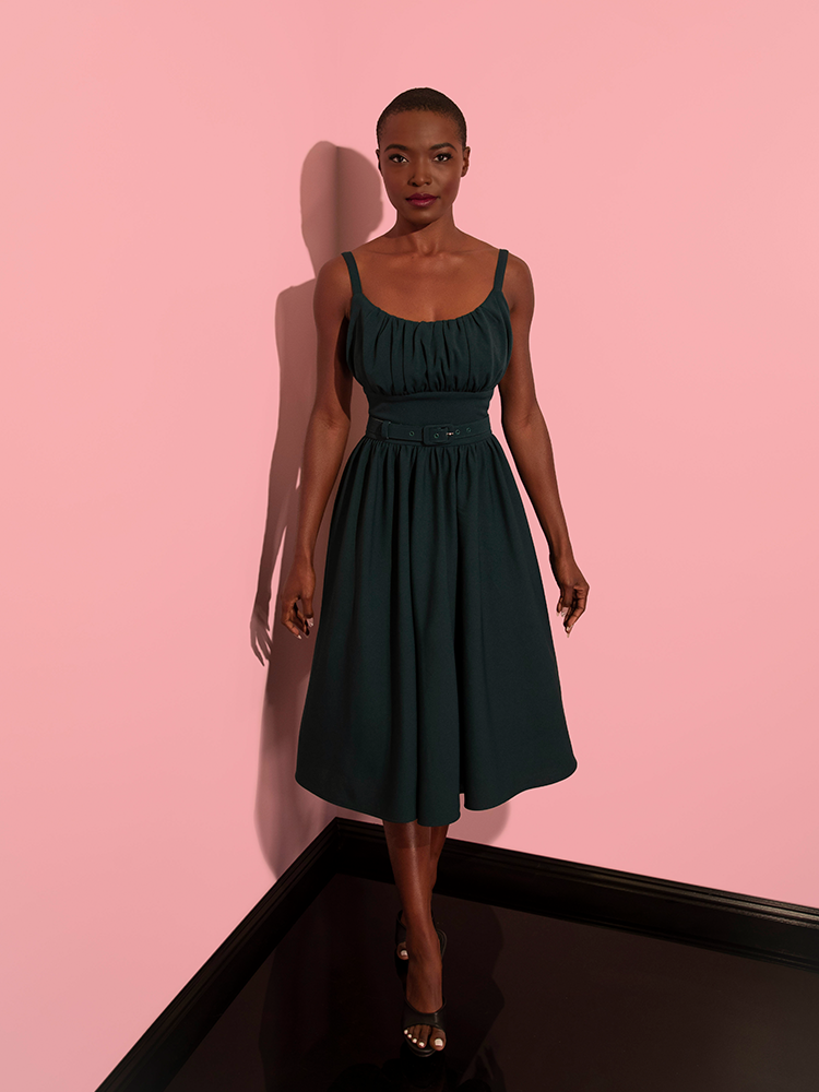 Model stares directly into the camera while wearing the Ingenue Dress in Hunter Green.