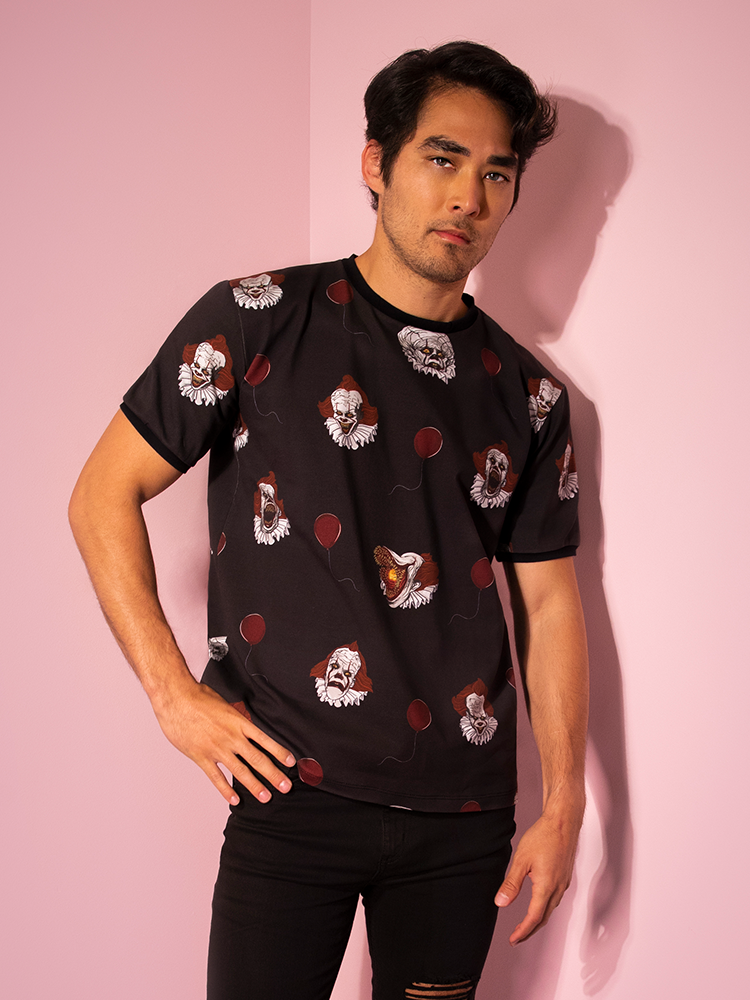 Looking at the camera with his hand on his hip, Ethan shows off the Pennywise ringer tee by Vixen Clothing.