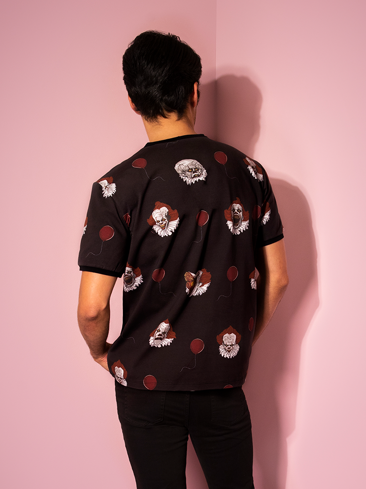 Turned away from the camera, Ethan models the back of the Pennywise ringer tee by Vixen Clothing.