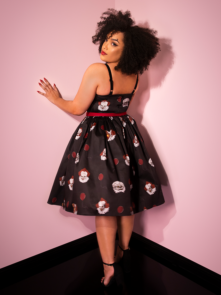 Looking over her shoulder mid twirl, Ashleeta shows off the back of the Pennywise sweetheart swing dress by Vixen Clothing.