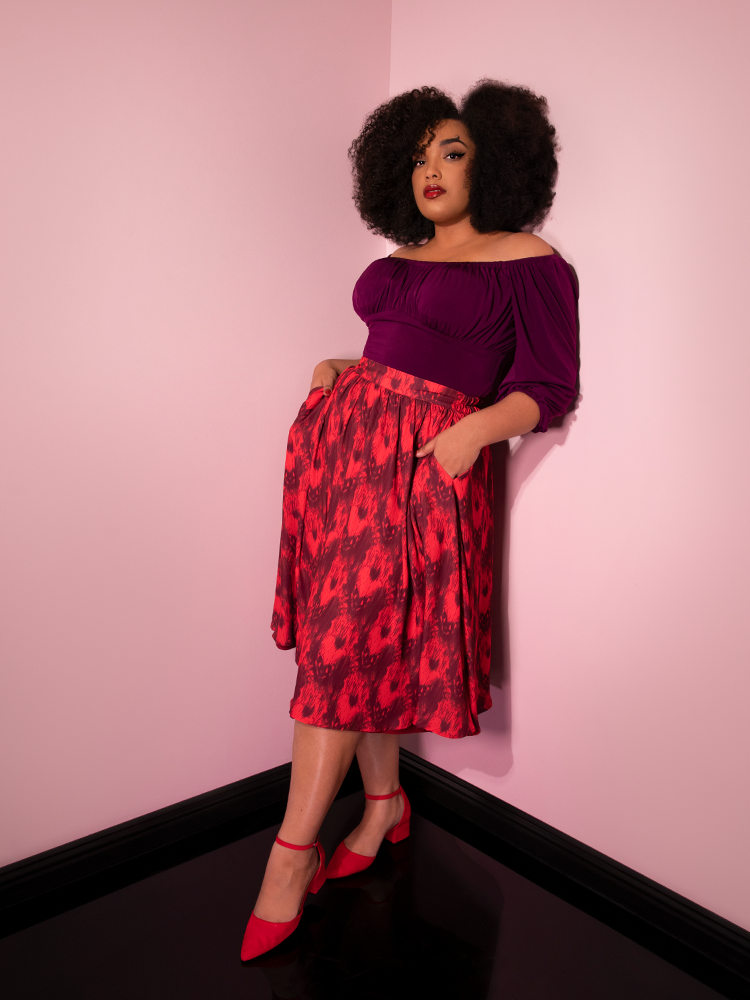 Looking into the camera with her hands in her pockets, Ashleeta models the Pennywise cottage skirt by Vixen Clothing.