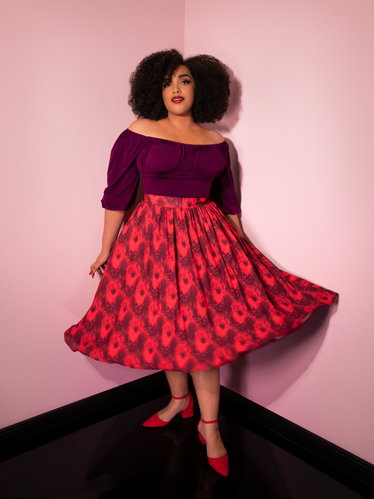 Looking into the camera while twirling, Ashleeta models the Pennywise cottage skirt by Vixen Clothing.