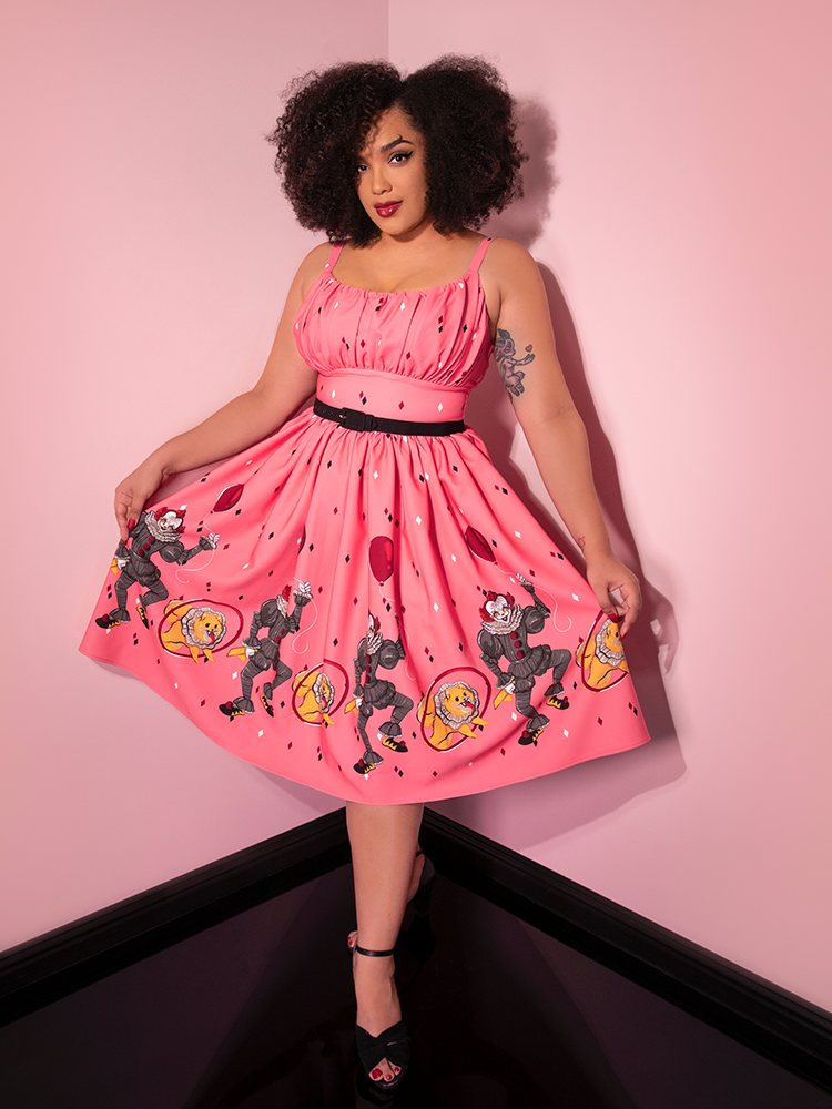 A full length shot of Ashleeta modeling the Dancing Clown Ingenue swing dress in pink by Vixen Clothing.