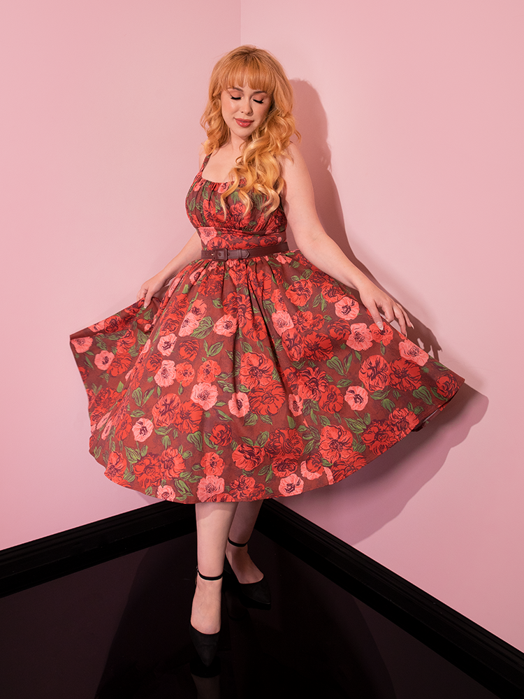 Model twirling around in the Ingenue Dress in Chocolate Rose Print allowing the skirt section to seemingly float.