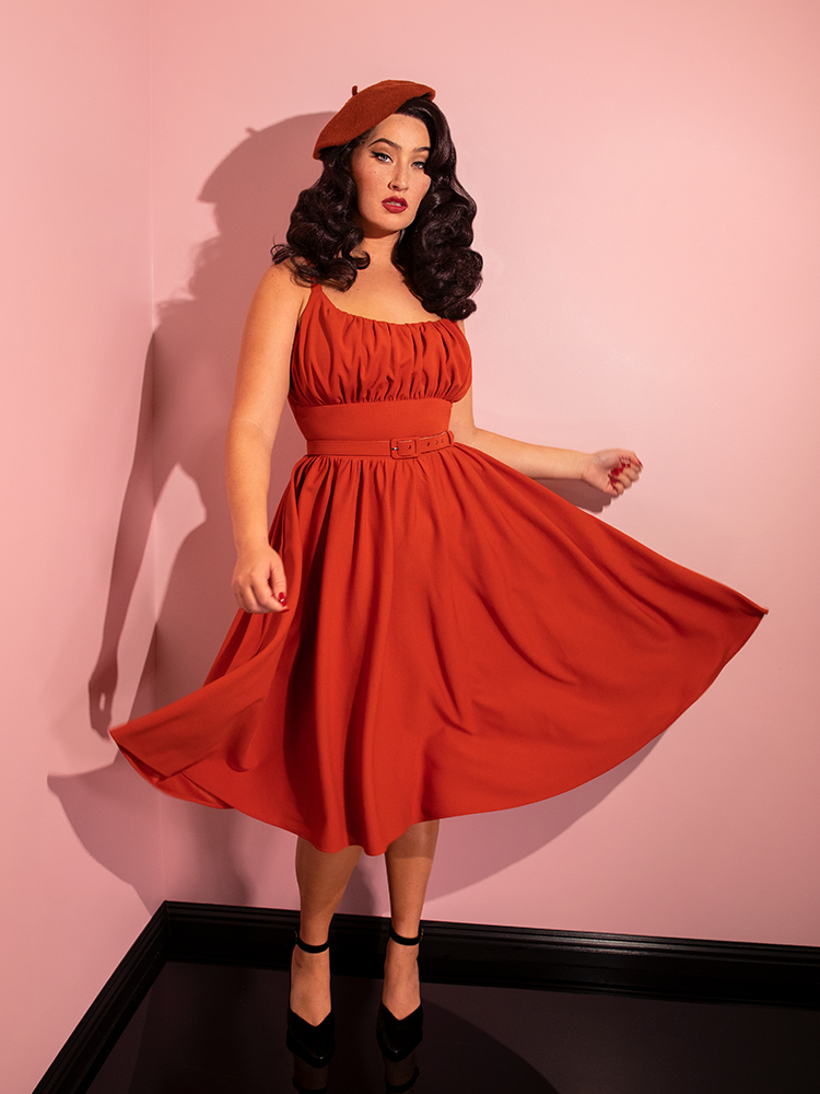 Francesca twirls while wearing the Ingenue Swing Dress in Pumpkin Spice from Vintage Clothing.