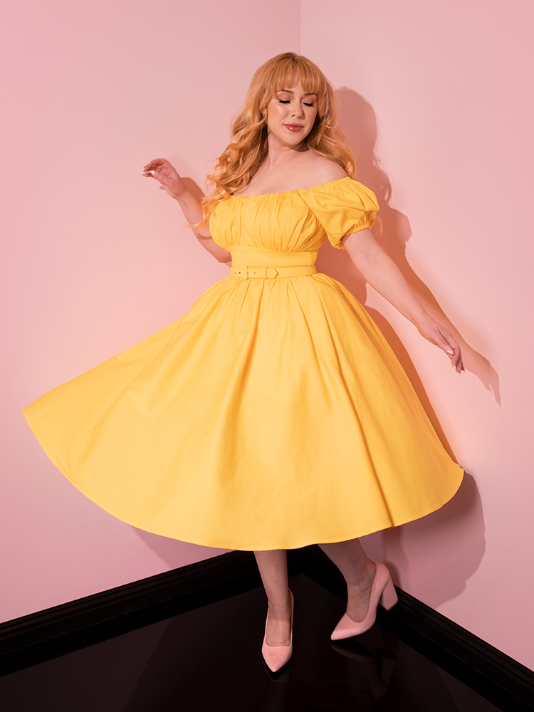 Model gracefully twirls around in the Lakeland Dress in Yellow giving us a glimpse of the gorgeous skirt section of the dress.
