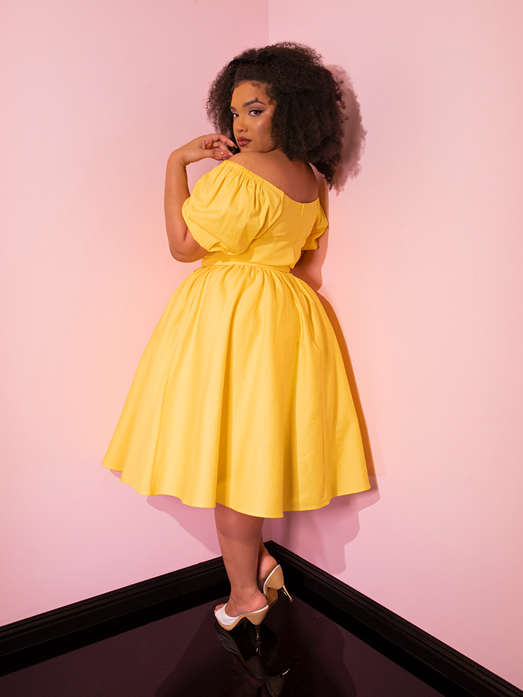 Model turned away from the camera to give us a glimpse of the side and back of the Lakeland Dress in Yellow.