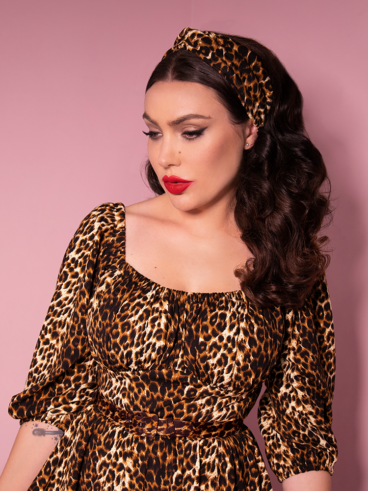 Looking off to the side, Micheline Pitt models Vixen Clothing's new retro inspired knot headband in leopard print.