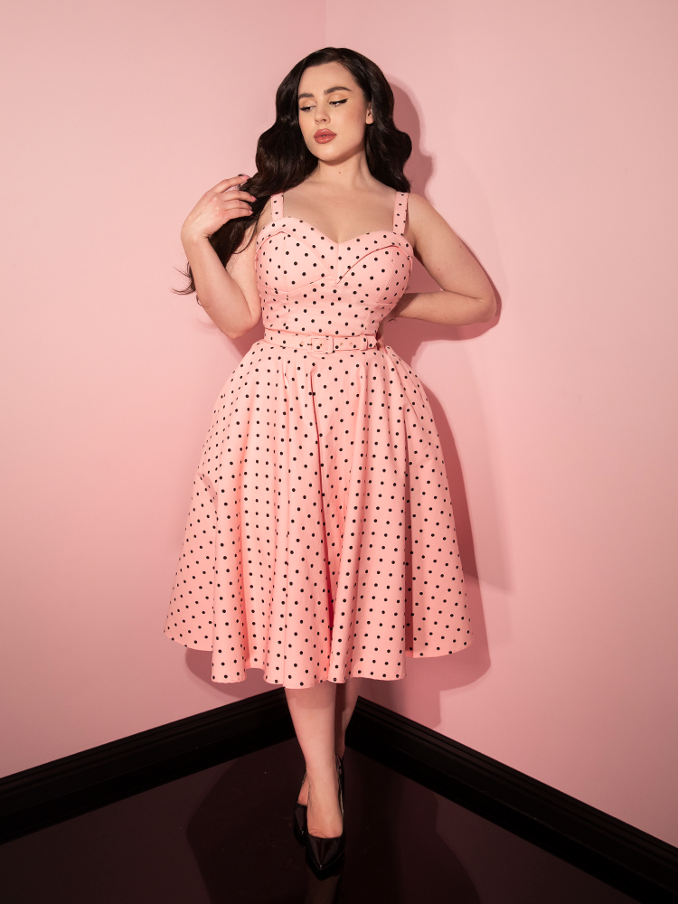 Full length shot of the Maneater Swing Dress in Rose Pink Polka Dot worn by Rachel Sedory. 