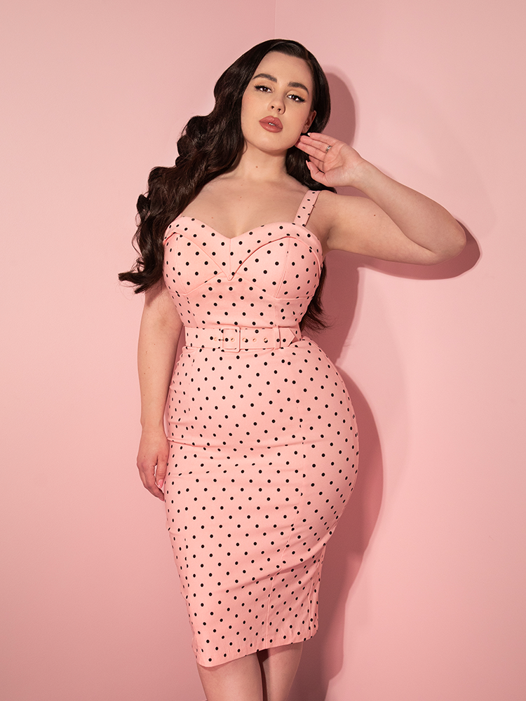 Rachel staring directly into the camera while wearing the Maneater Wiggle Dress in Rose Polka Dot from vintage clothing company Vixen Clothing.