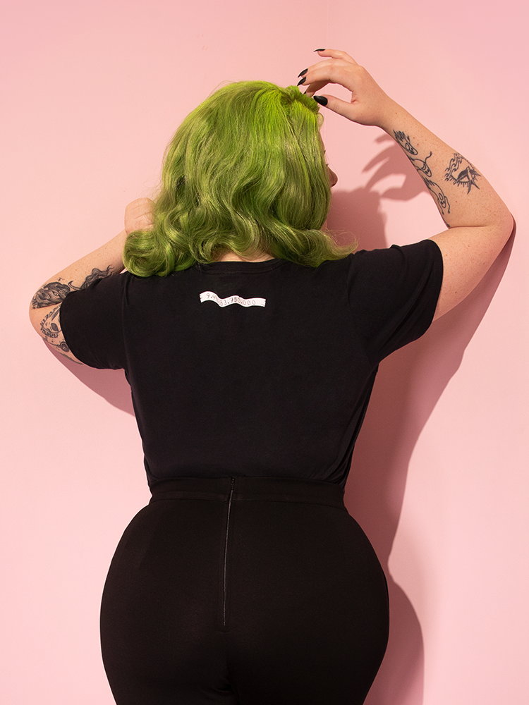 Shot of the back of the Miss Argentina Tee tucked into black retro pants - all items available from Vixen Clothing.