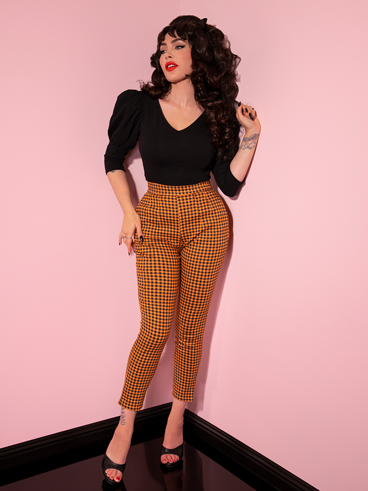 The Cigarette Pants in Orange Pumpkin Gingham worn by Micheline Pitt of retro clothing company Vixen Clothing.