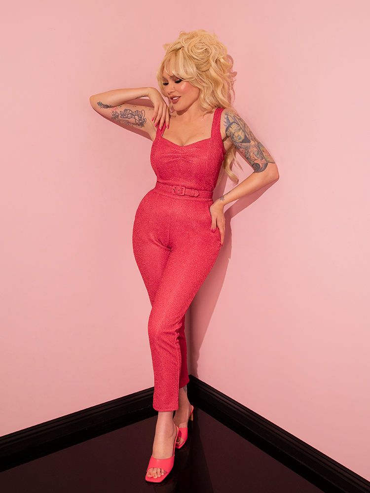 With a touch of nostalgia, the gorgeous model showcases the Cigarette Pants in Candy Pink Lurex from Vixen Clothing, perfectly embodying the vintage aesthetic.