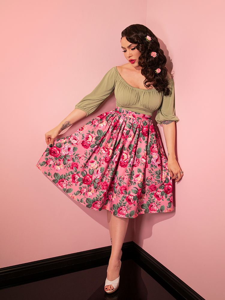 Full length shot of Micheline Pitt in a seafoam green retro top and the Vixen Swing Skirt in Pink Rose Print.