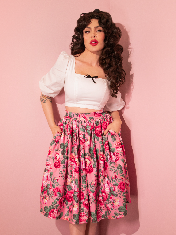 Micheline tucking her hands into the pockets of her skirt as she wears the Darling Crop Top in White.