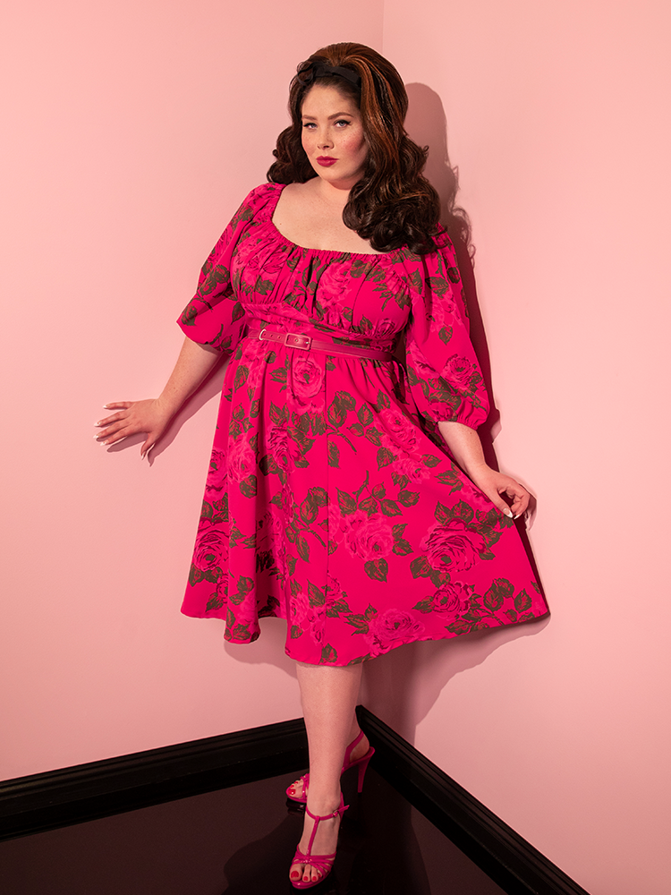 Full length shot of a female model wearing the Vacation Dress in Hot Pink with Pink Roses from retro dress brand Vixen Clothing.