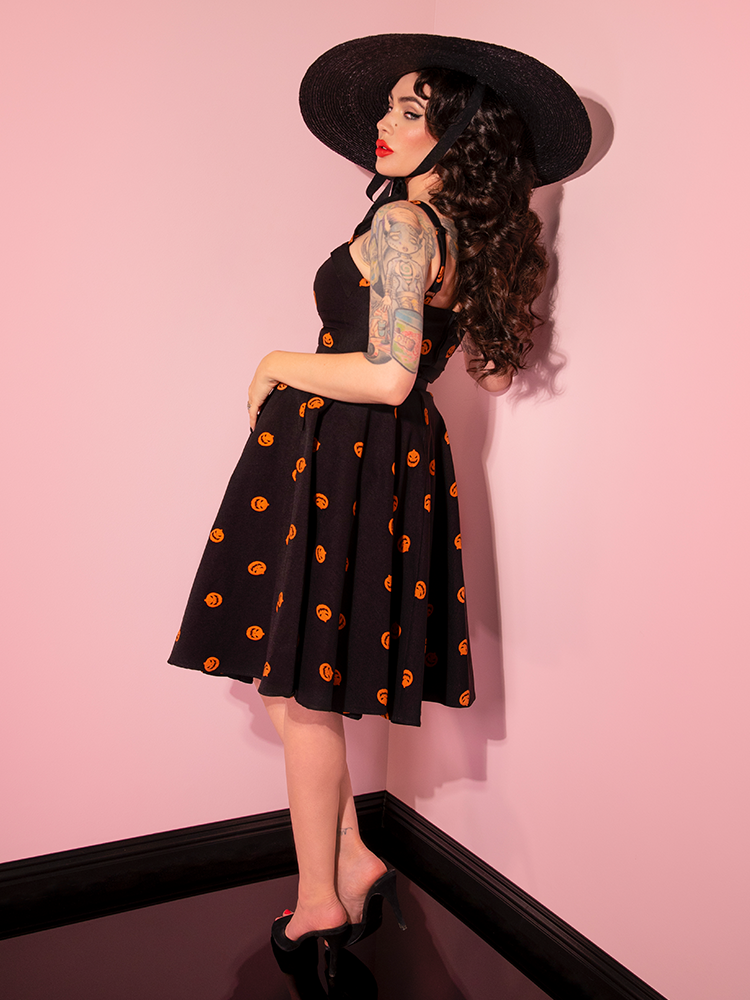 Micheline Pitt turned away from the camera to show off the back and side of the Pumpkin King Maneater Swing Dress in Black.