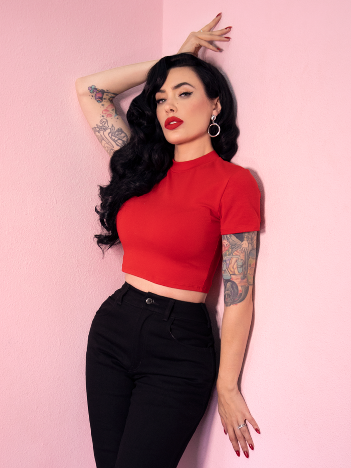 Standing while wearing the Bad Girl Crop Top in Red and Black pants, Micheline Pitt shows off a sexy but simple retro style outfit.
