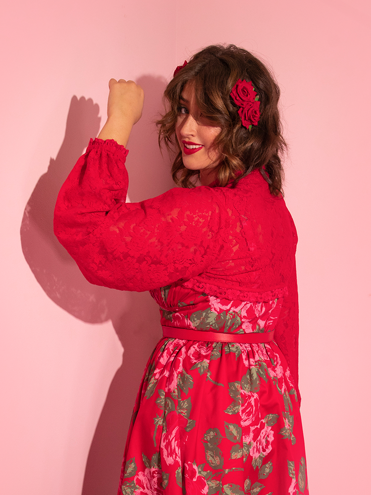 Francesca turned away from the camera but peering over her left shoulder, holds her arm up to show off the gorgeous Vixen Vintage Lace Bolero in Classic Red she's wearing.