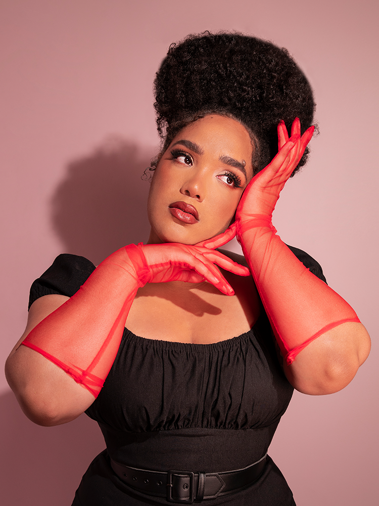 The Vintage Inspired Sheer Gloves in Red being worn by vintage clothing model.