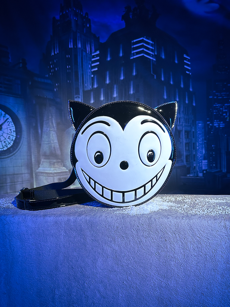 The BATMAN RETURNS™ Shreck’s Cat Backpack shot in front of a dark city theme backdrop.