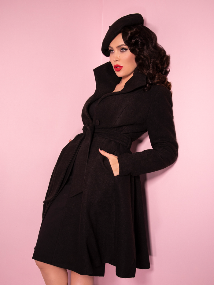 Looking like she stepped right off the screen of the latest James Bond movie, Micheline Pitt shows off the Starlet Swing Coat in Black from Vixen Clothing