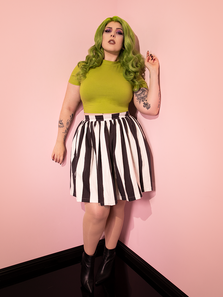 The Ghost Skater Skirt in Black & White Stripes worn with a short sleeve green top.