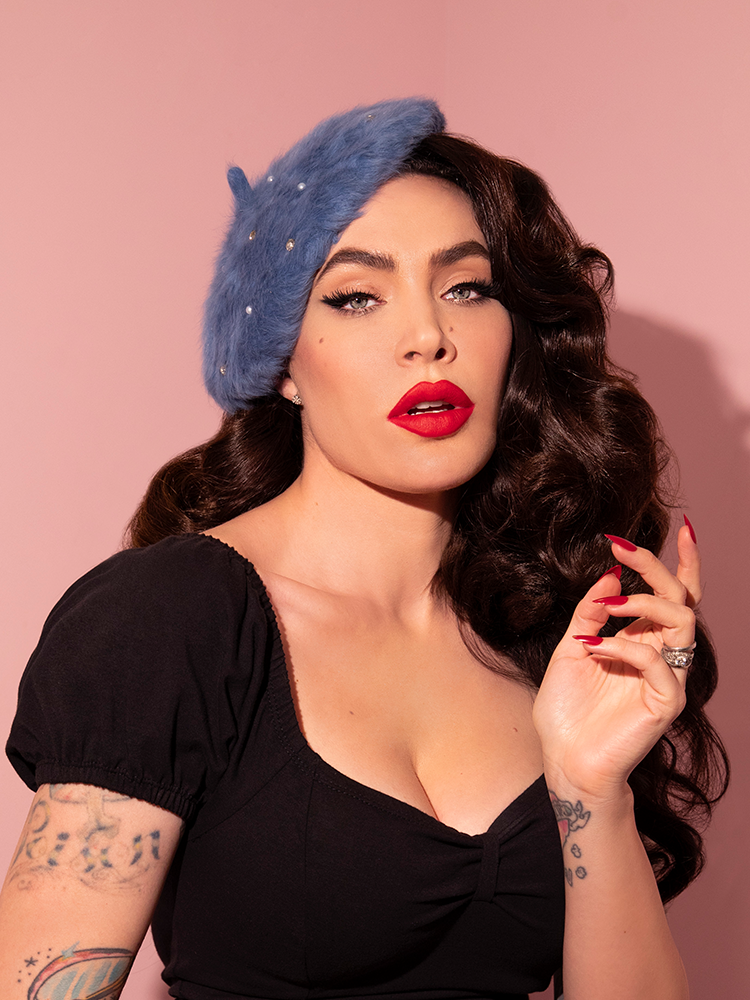 Micheline Pitt strikes a whimsical pose while modeling the Vintage Style Beret with Rhinestones in Sunset Blue.