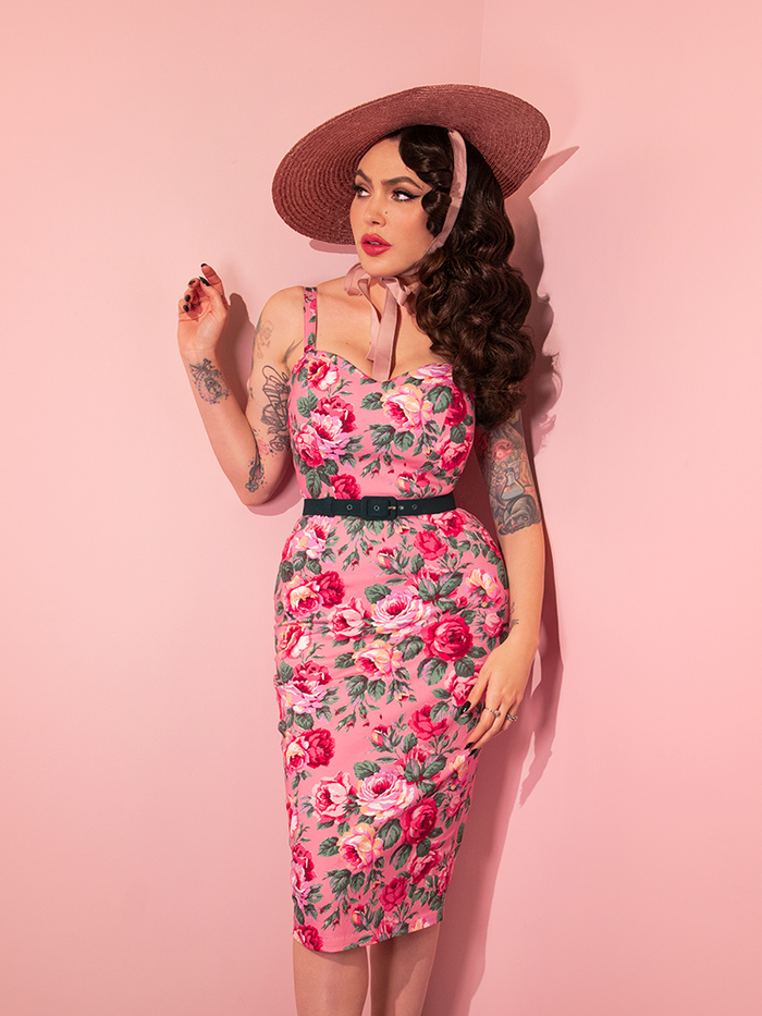 Micheline Pitt wearing the Sweetheart Wiggle Dress in Pink Rose Print along with a pink sunhat.
