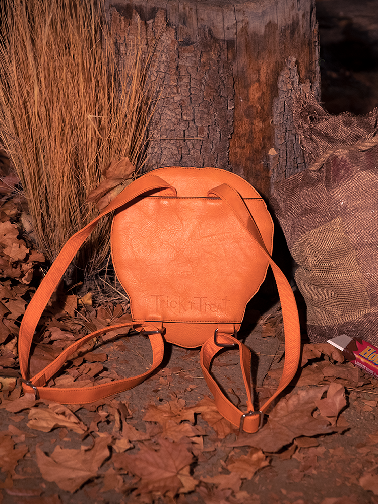 The back of the TRICK R TREAT™ Sam Backpack In a spooky, leafy section.