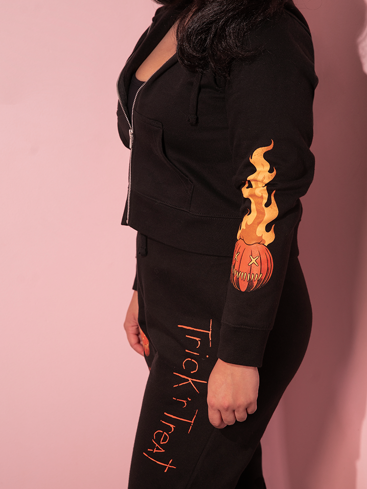 The TRICK R TREAT™ Jack O' Lantern Sweatpants shot from the side on a female model.