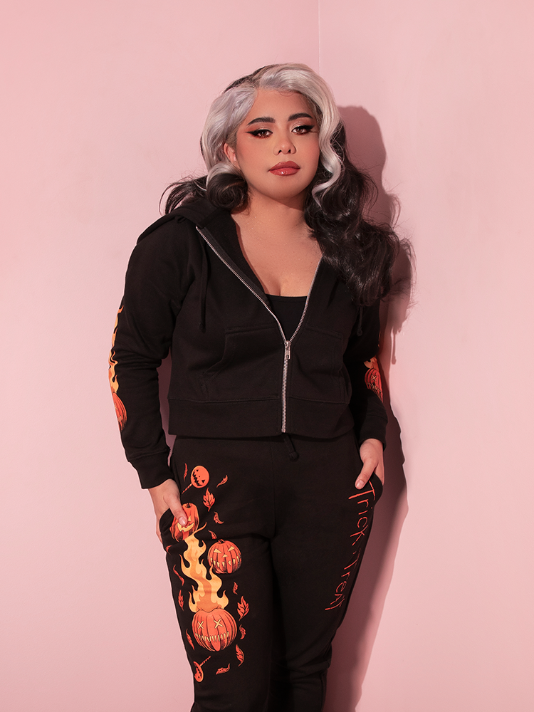 Model with her hands tucked into the side pockets of her black sweatpants that she's wearing with the matching TRICK R TREAT™ Sam Cropped Hoodie.