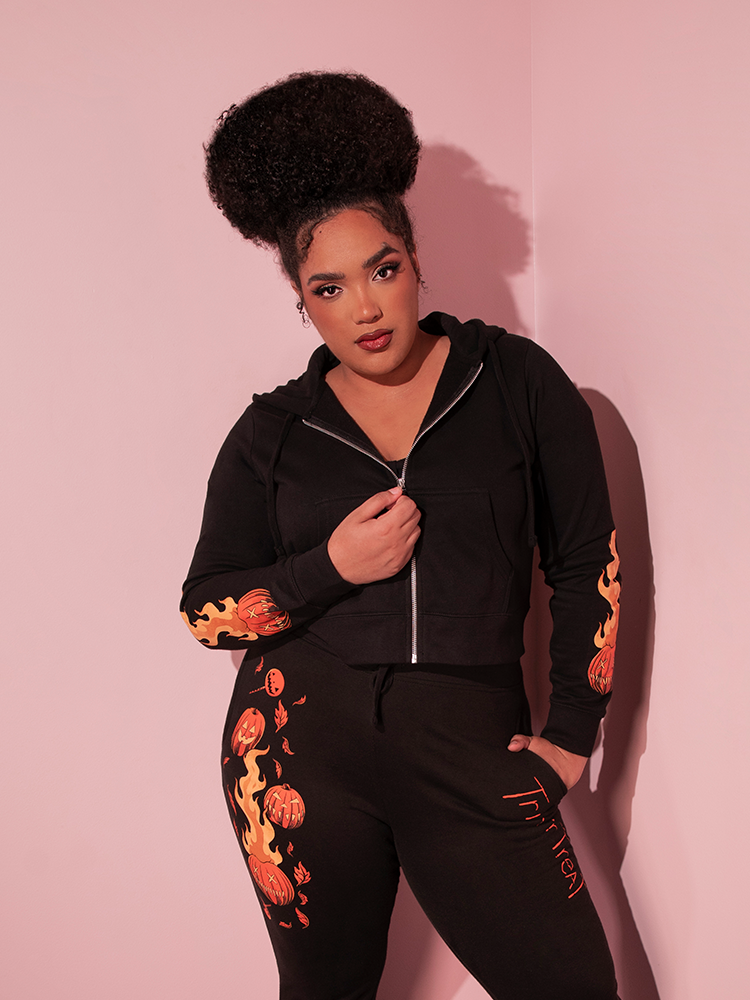 Female model wearing the TRICK R TREAT™ Sam Cropped Hoodie with matching sweatpants - all items made by and available at Vixen Clothing.