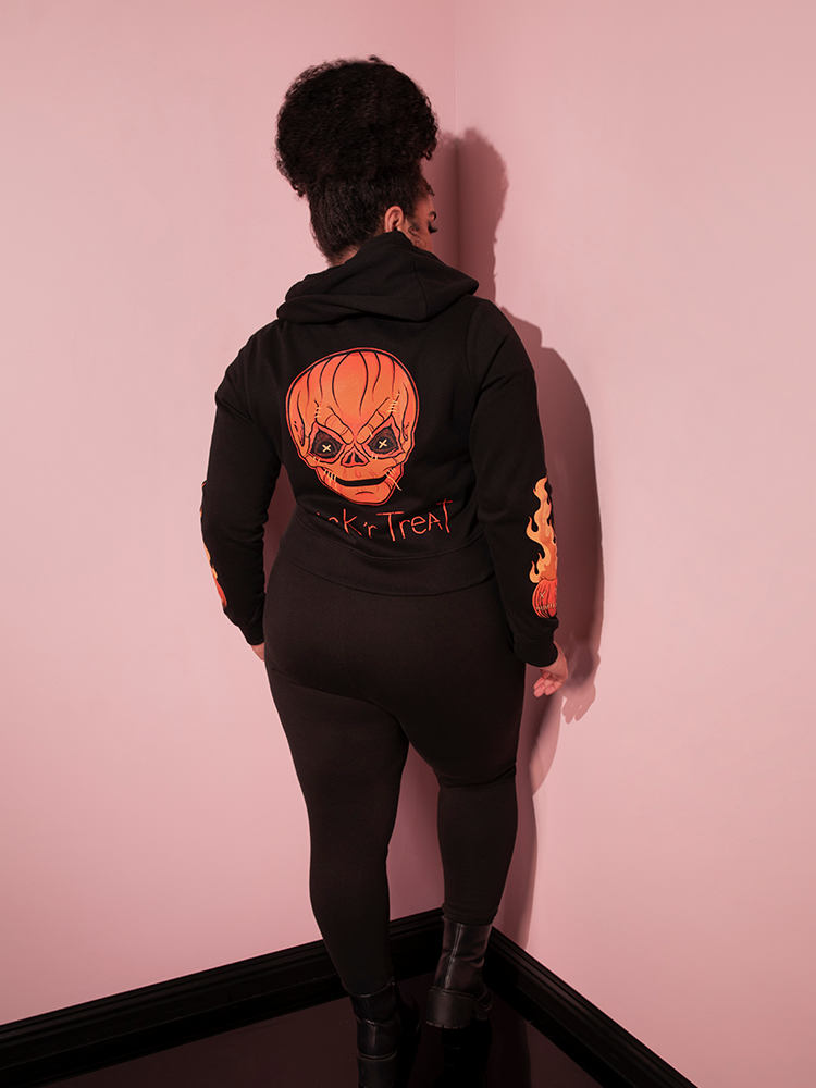 The back of the TRICK R TREAT™ Jack O' Lantern Sweatpants as modeled by female model from Vixen Clothing.