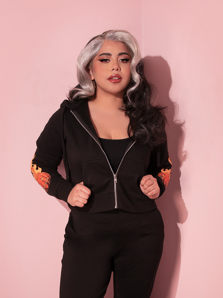 Model with her thumbs tucked into the pockets on the TRICK R TREAT™ Sam Cropped Hoodie.