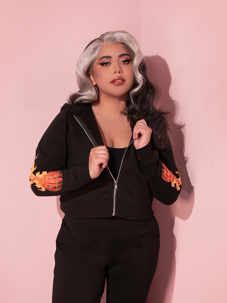 Model posing with her hands holding onto the opposing sides of the TRICK R TREAT™ Sam Cropped Hoodie.
