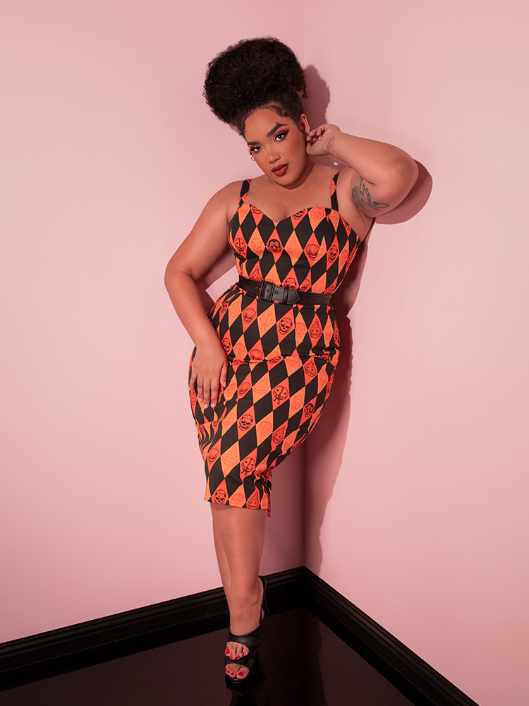 The TRICK R TREAT™ Sweetheart Wiggle Dress in Halloween Harlequin Print from retro dress company Vixen Clothing being worn by female model.