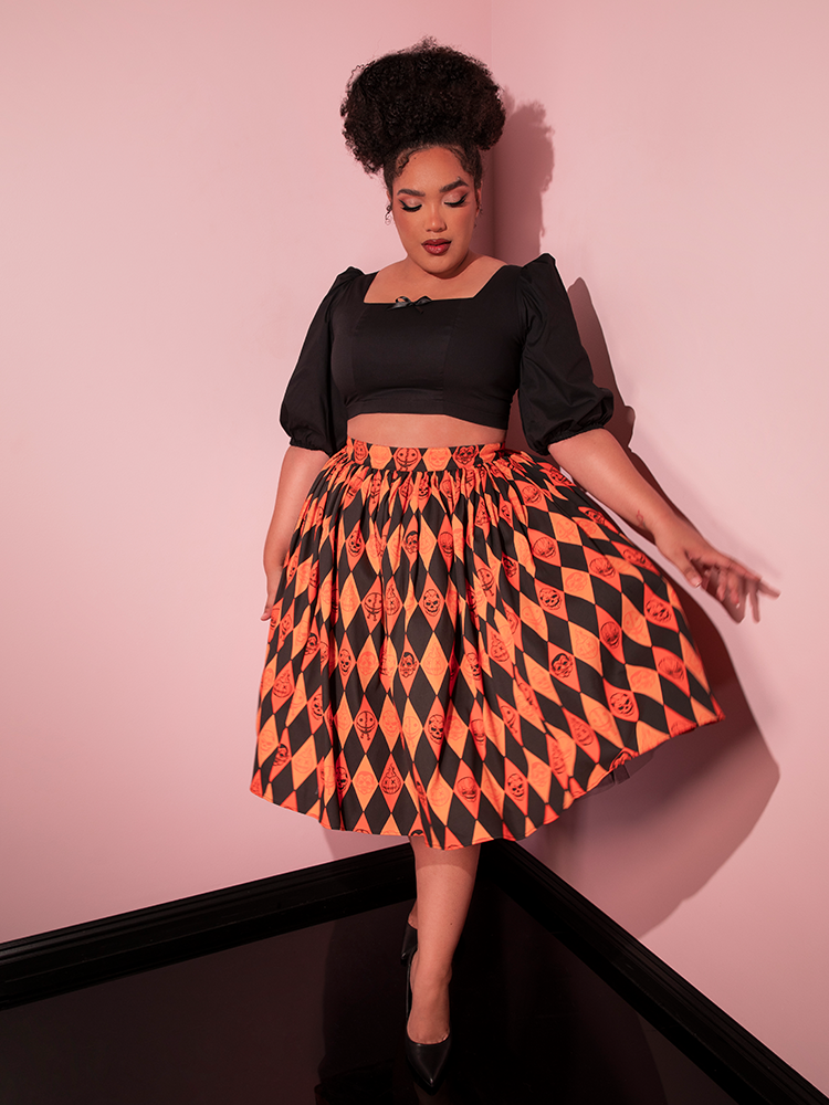 Model flings out the side of the TRICK R TREAT™ Swing Skirt in Halloween Harlequin Print to show off the spooky print.